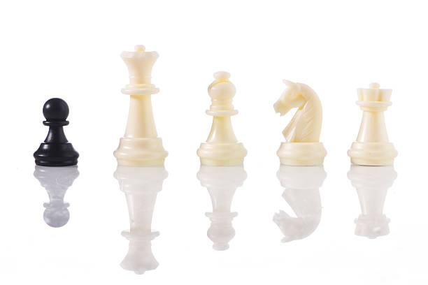 istock white pawn on a chessboard with black chess pieces 537468824