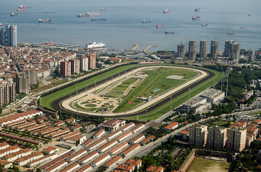 Istanbul, Turkey - May 30, 2016:  Aerial view of the Veliefendi Racecourse in Istanbul.  In the foreground are stables and behind, the Marmara Sea with many tankers waiting to travel along the Bosphorus Strait to the Black Sea.
