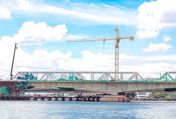 istock Crane beside the river on clearing sky background 537469804