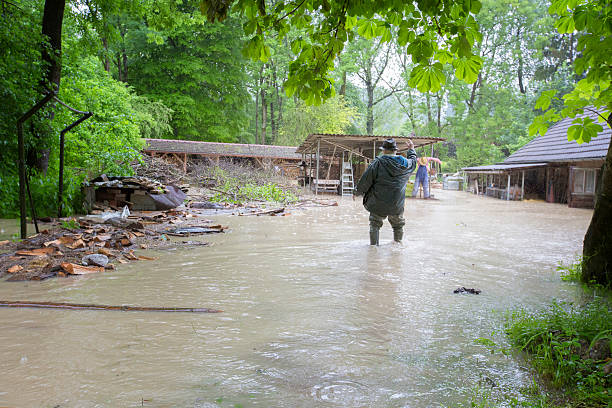 An engorged river overflows it's banks flooding a clothing factory.