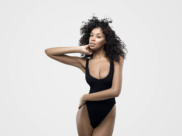 Portrait of young woman wearing bikini Portrait of young woman wearing bikini against isolated white background. Image taken with Hasselblad H5D 50C camera system and developed from camera RAW. black women in bathing suits stock pictures, royalty-free photos & images
