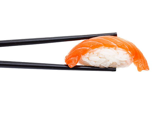 istock Salmon sushi nigiri in chopsticks isolated on white background 537471164