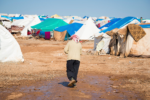 Atmeh, Syria - January 14, 2013: A Syrian refugee walks at the camp for internally displaced persons in Atmeh, Syria, located adjacent to the Turkish border