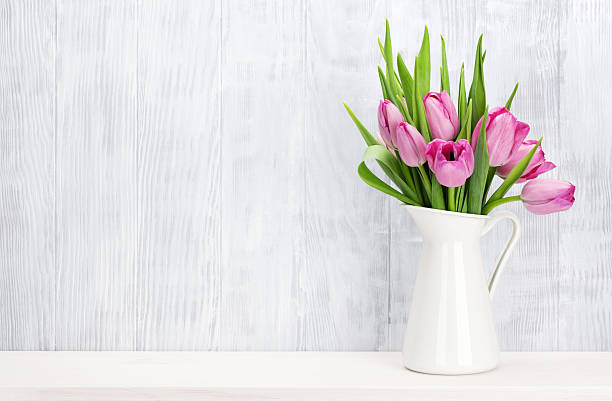 Fresh pink tulip flowers bouquet Fresh pink tulip flowers bouquet on shelf in front of wooden wall. View with copy space jug photos stock pictures, royalty-free photos & images