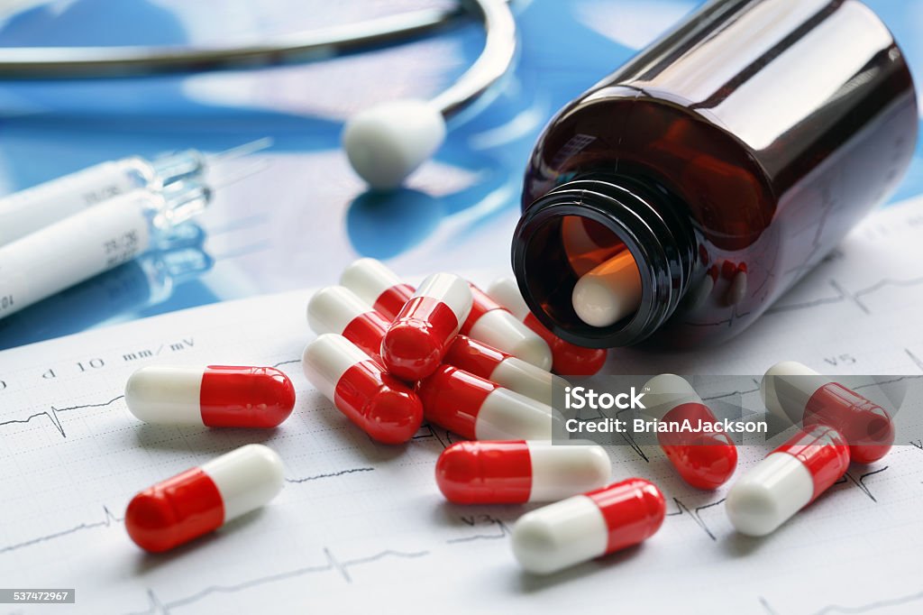 Prescription drugs Prescription medicine pill bottle and syringe on cardiogram printout 2015 Stock Photo