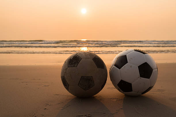 istock Two footballs on the beach 537473164