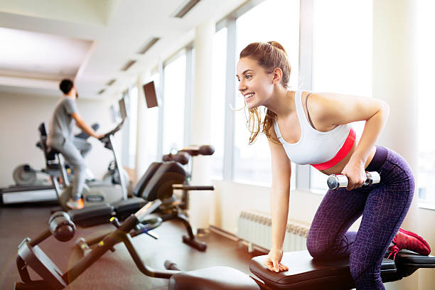 istock Beautiful woman lifting weights in gym 537474752