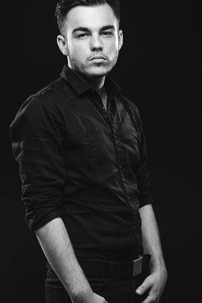 istock Serious man with beard is standing in classic black shirt 537477576