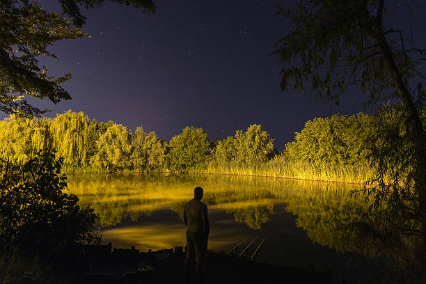 istock Fisherman in night , Night Fishing, Carp Rods, starry night reflection 537477688