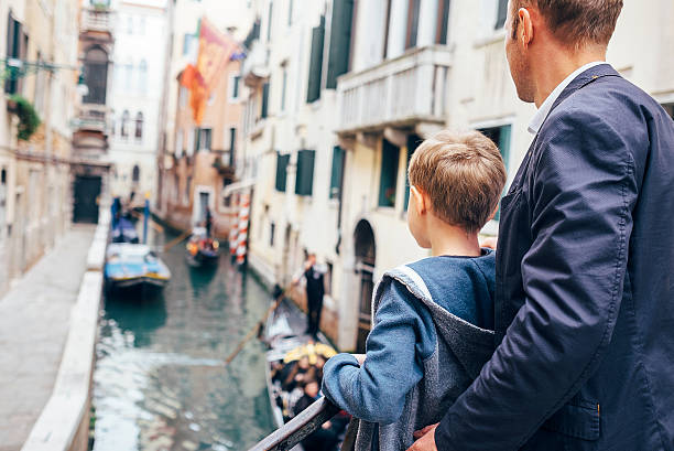 istock Father and son look together on venecian gondolas 537477930
