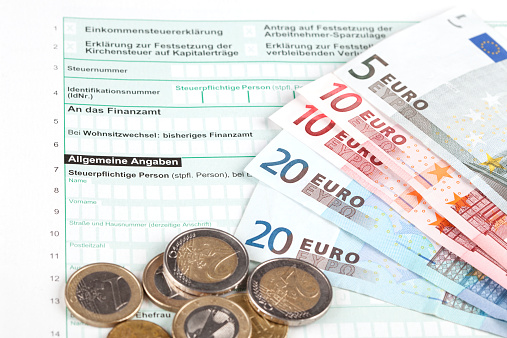 German Tax Form with Euro banknotes and coins, selective focus