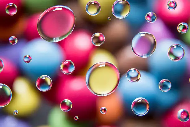 smarties sweets magnified through water droplets