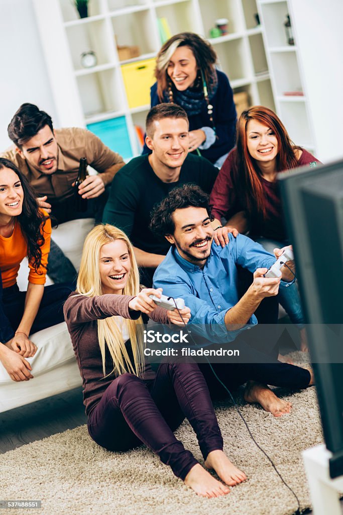 Friends having fun Cheerful Group Of Young Friends Playing Video Games At Home Gamer Stock Photo