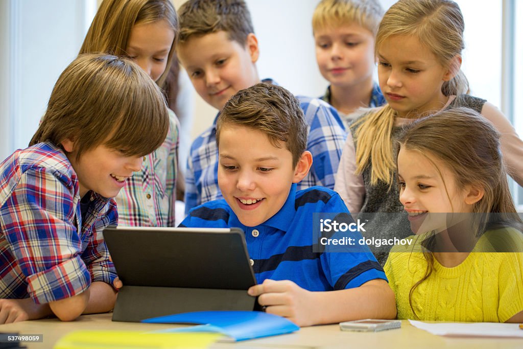 Grupo de niños de escuela con tableta en montaje tipo aula - Foto de stock de Niño libre de derechos