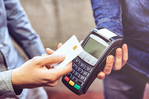 Customer and cashier in a store paying using a contactless card