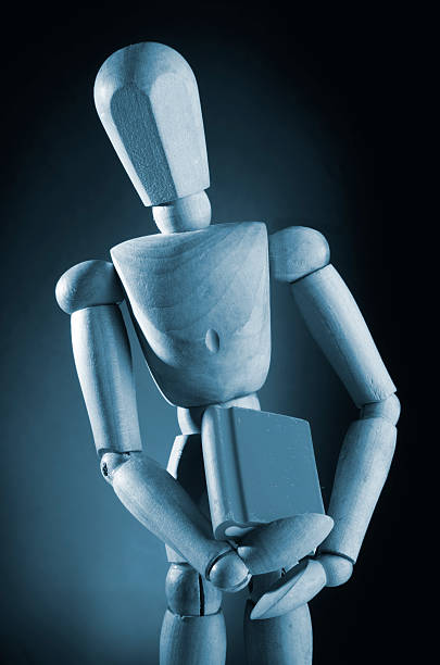istock Wooden man holding book in black and white. 537499479