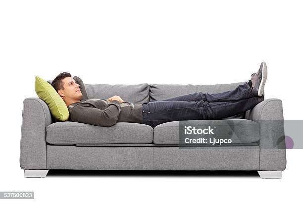 Pensive Young Guy Laying On A Sofa Stock Photo - Download Image Now - Sofa, Men, Lying Down