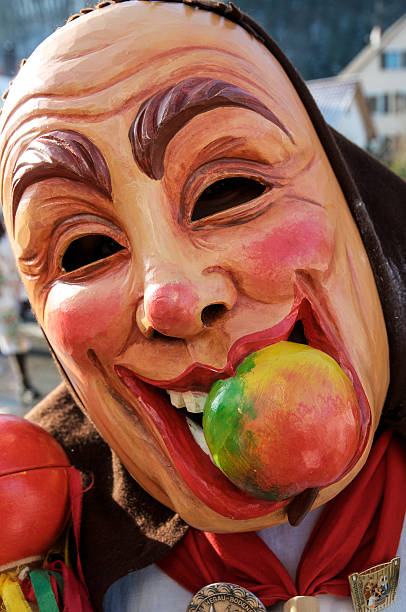 Traditional mask bearer Konstanz, Germany - February 15, 2009: A dressed up person with a traditional mask and an apple in his mouth on a carnival procession. fastnacht stock pictures, royalty-free photos & images