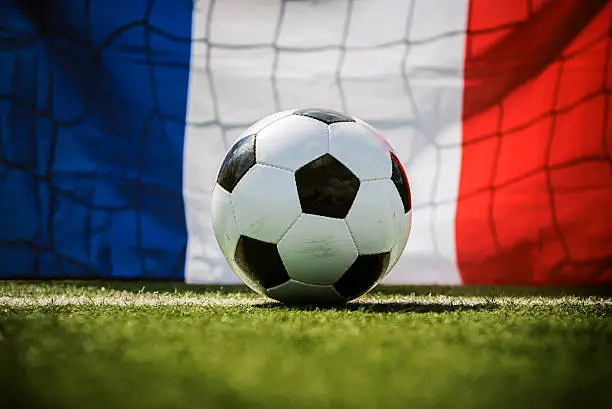 soccer ball on green soccer field with french flag