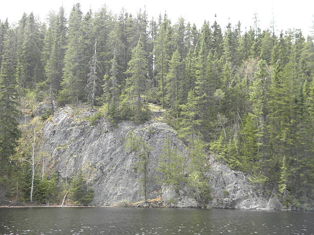 istock rocky cliff shore with trees & northern river. 537515229