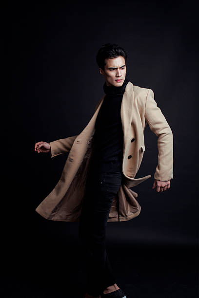 istock cool real young man in coat on black background posing 537515231