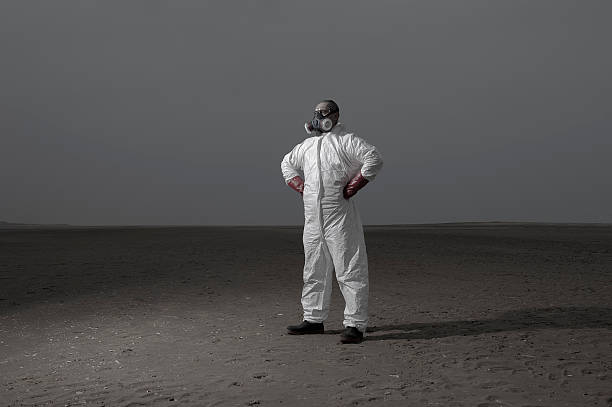 Mann im Schutzanzug steht in Öde Landschaft – Foto