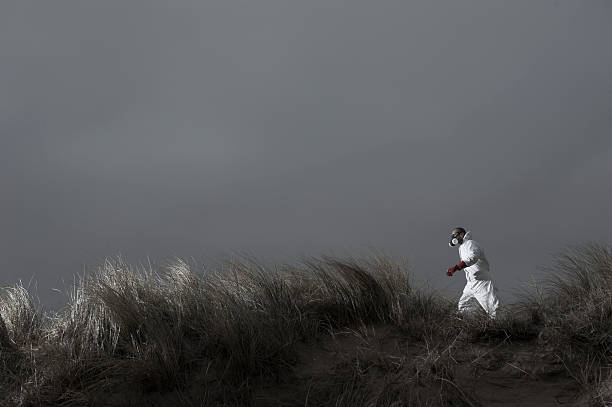 Hombre en traje de protección de riesgos paseos en extraño paisaje - foto de stock