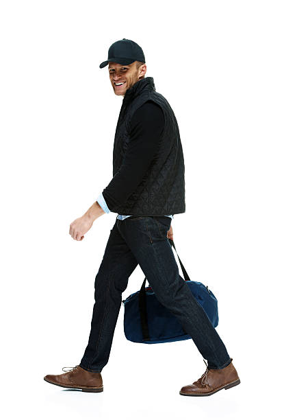 istock Cheerful man holding duffle bag & walking 537515843