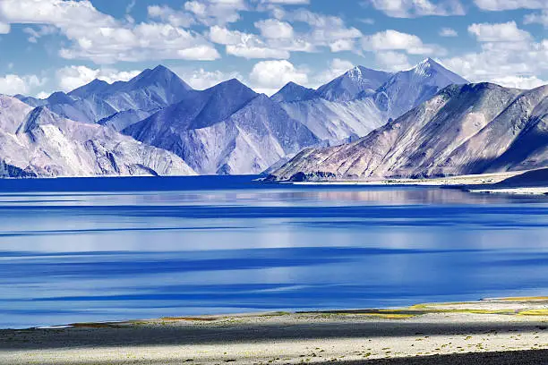 Mountains and Pangong tso (Lake). It is huge lake in Ladakh, altitude 4,350 m (14,270 ft). It is 134 km (83 mi) long and extends from India to Tibet. Leh, Ladakh, Jammu and Kashmir, India