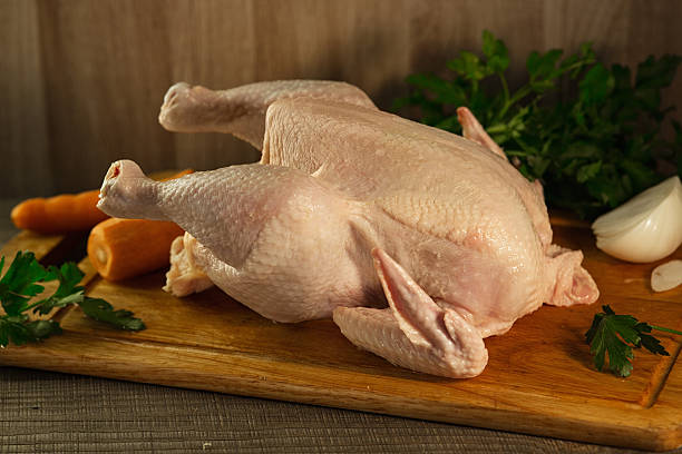 istock Whole raw chicken on a wooden table 537519732