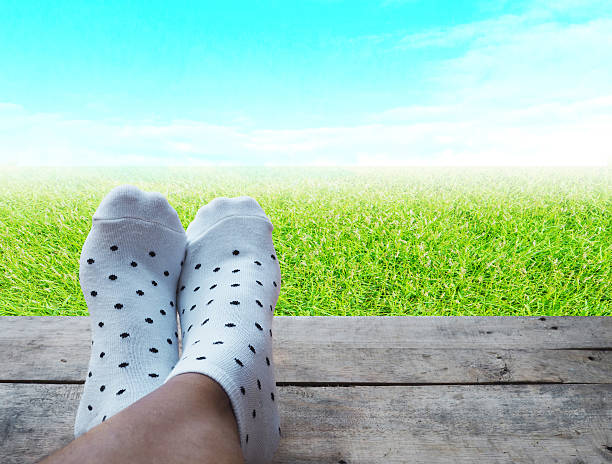 istock feet on wooden floor grass and blue sky background 537531054