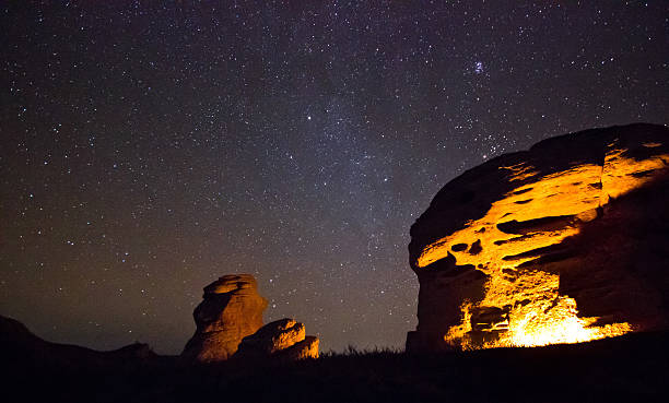 istock bounfire lights big rock with sitting man 537531939