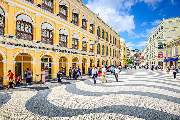 Macau, China at Senado Square Macau, China - May 21, 2014: People enjoy Senado Square. The territory was the last European colony in Asia and the architecture is inspired by the former Portuguese rule. macao photos stock pictures, royalty-free photos & images