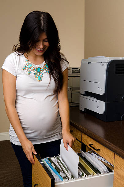 istock Pregnant beauty at filing cabinet 537533527