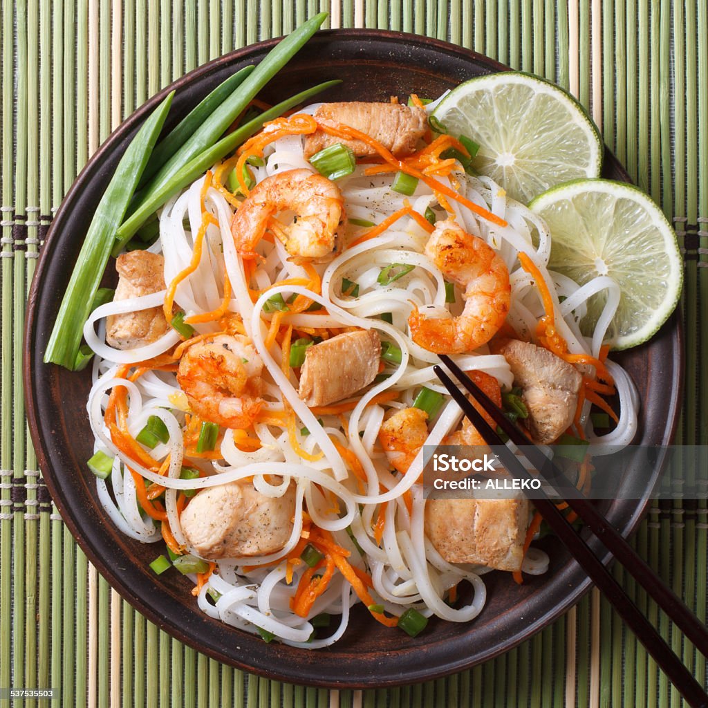 rice noodles with chicken, shrimp and vegetables closeup Asian food: rice noodles with chicken, shrimp and vegetables closeup. horizontal view from above 2015 Stock Photo