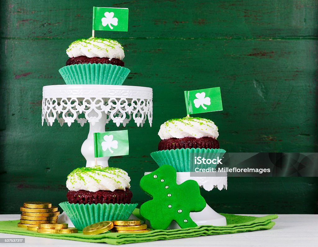 Happy St Patricks Day cupcakes Happy St Patricks Day cupcakes with green theme decorations on vintage style green wood background. 2015 Stock Photo