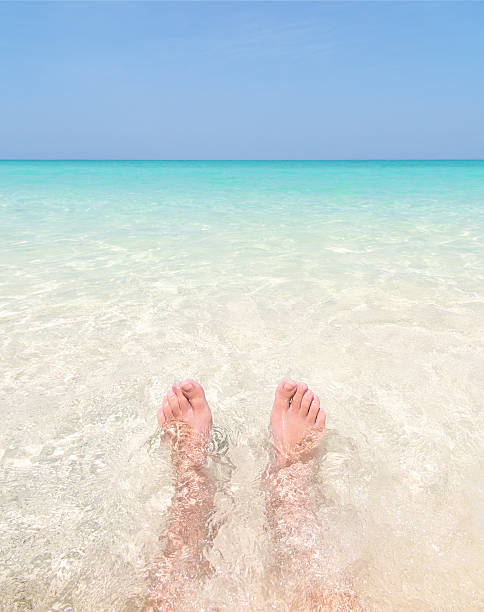 istock Feet in clear water on paradise beach. 537537676