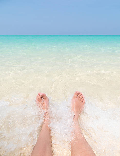 istock Feet in water on paradise beach with crashing wave. 537537730