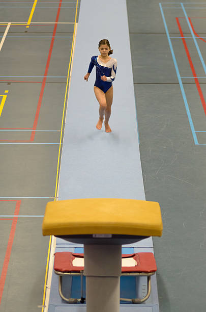 Young gymnast girl performing jump stock photo