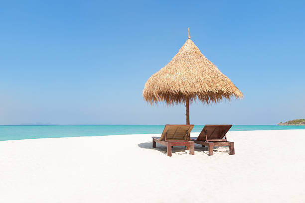istock Wooden deck chairs under traditional straw parasol on paradise beach. 537537868