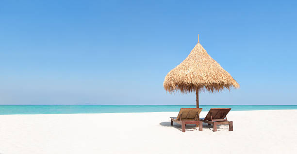 istock Wooden deckchairs and straw parasol on paradise beach. 537538324