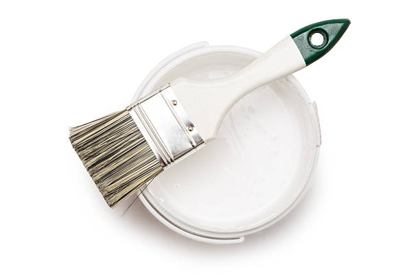 Can of white paint with brush