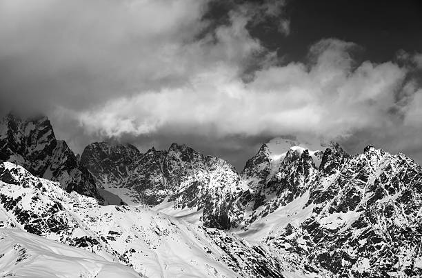 istock Black and white snowy rocks in clouds 537539252