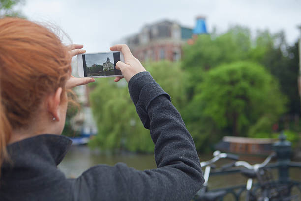istock Happy girl using a smart phone in Amsterdam City 537541388