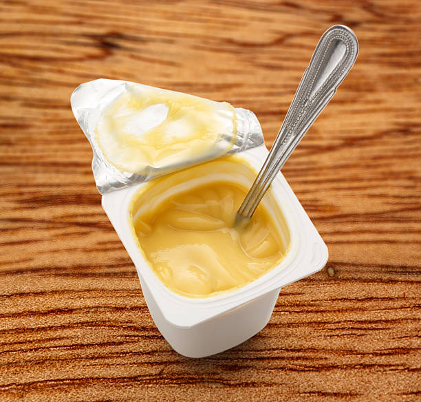istock Open yogurt in pot with metal spoon 537542844