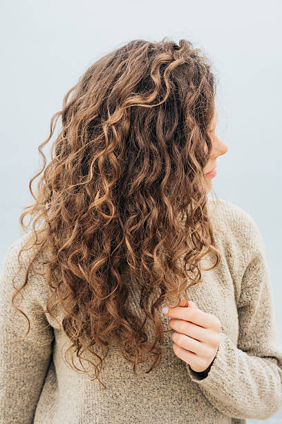 istock Curly brunette in a sweater on the coast 537543688