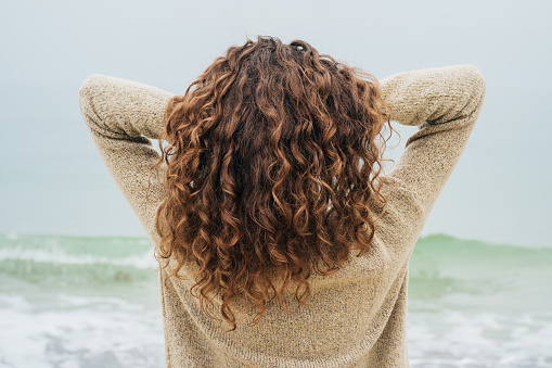 brunette rizado en un tejido sobre la costa photo