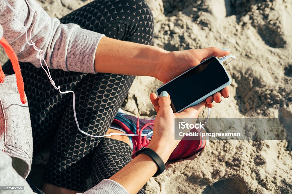 Chica en ropa deportiva escuchando música con auriculares - Foto de stock de Teléfono libre de derechos