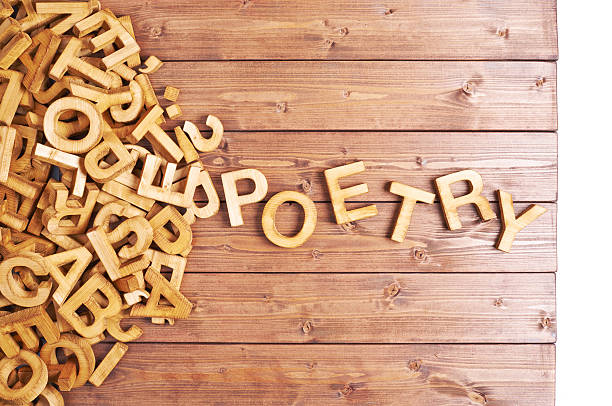 Word poetry made with wooden letters Word poetry made with block wooden letters next to a pile of other letters over the wooden board surface composition poetry stock pictures, royalty-free photos & images