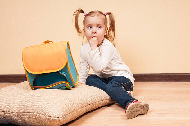 chica con una escuela, bolsa - finger in mouth fotografías e imágenes de stock